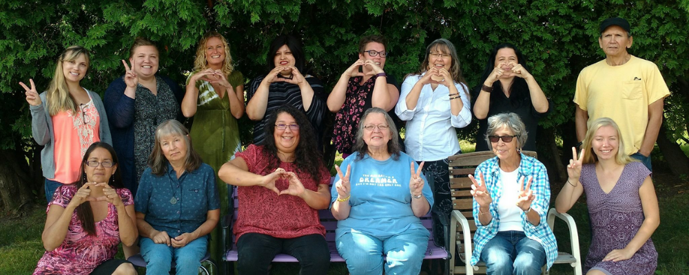 group of people make hearts and peace signs with their hands
